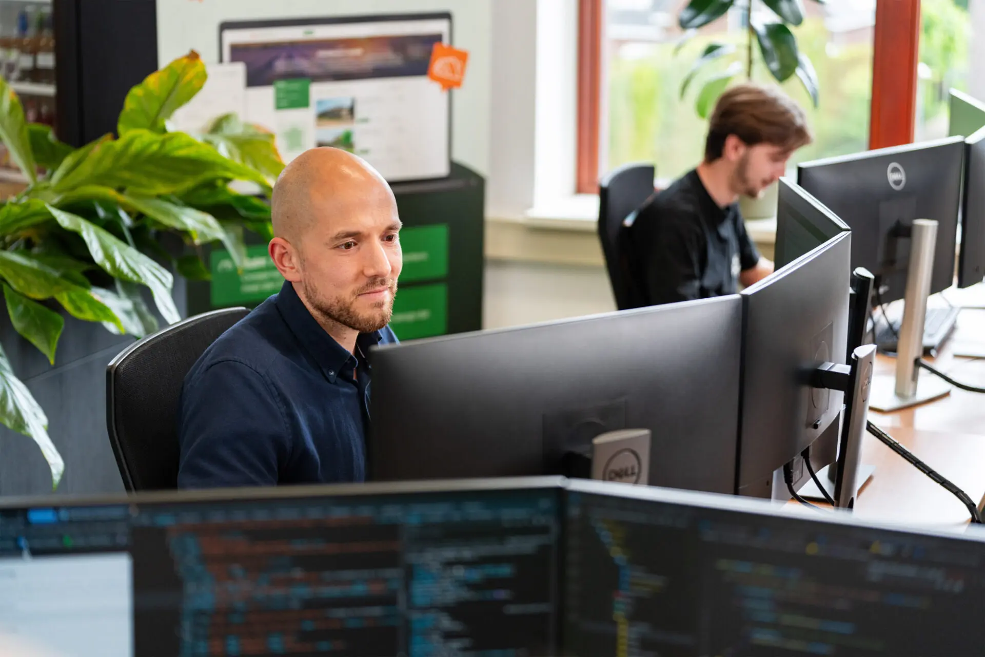 Kale man kijkt lachend naar zijn computerscherm