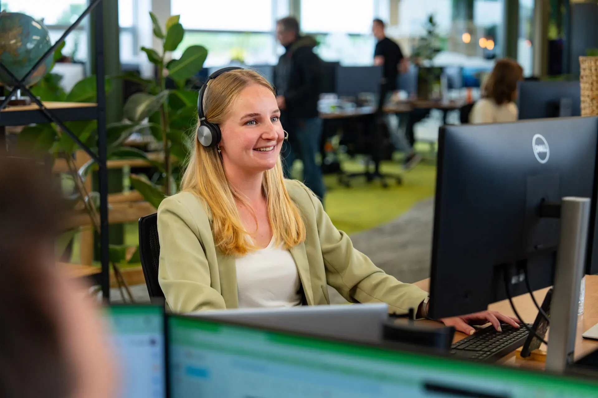 Lachende vrouw achter computer met headset