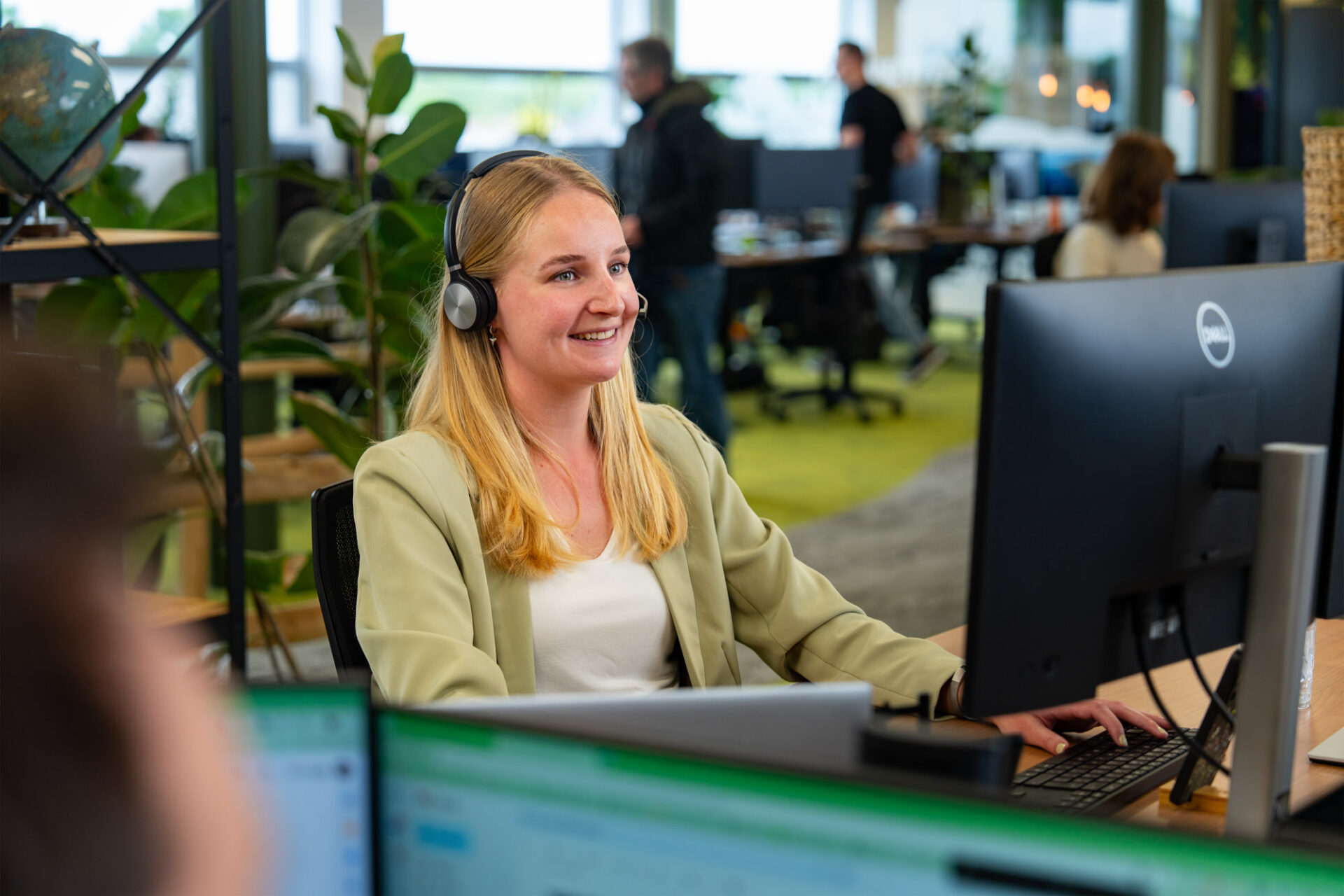 Lachende vrouw achter computer met headset