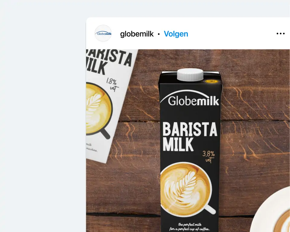 Een kartonnen verpakking van Globemilk Barista Milk 3,8% vet, met een kop koffie met latte art op de voorgrond, geplaatst op een houten tafel.