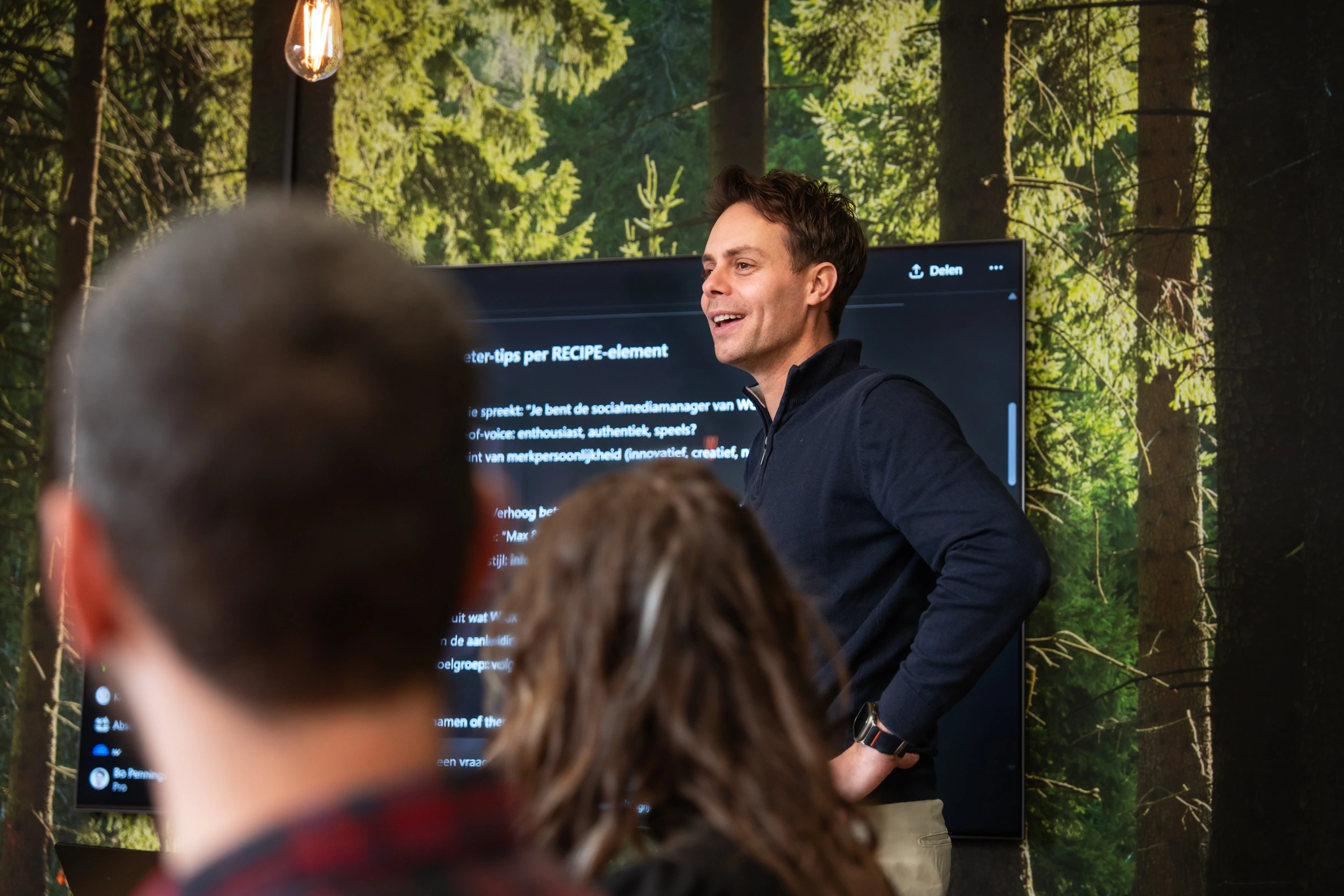 Een spreker geeft een interactieve presentatie over de beïnvloedingsprincipes van Cialdini aan een groep toehoorders, met een scherm op de achtergrond waarop belangrijke tips worden getoond.