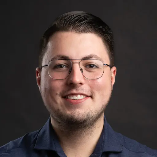 Lachende man met bril op voor zwarte achtergrond, portretfoto