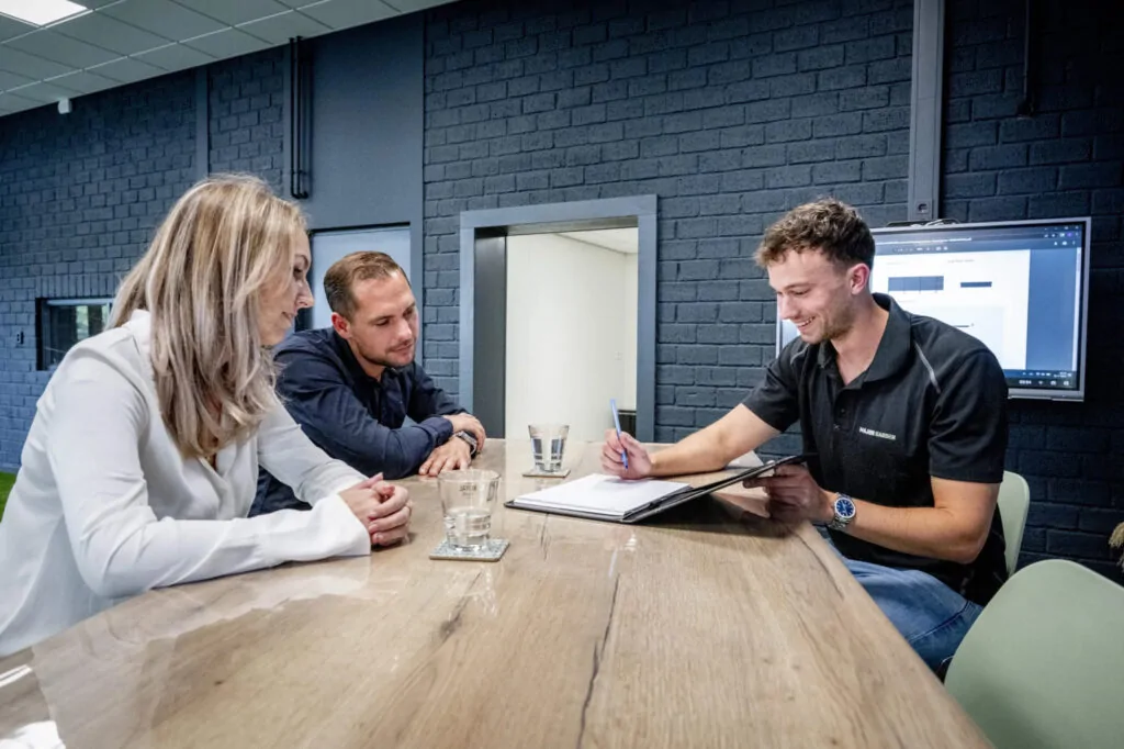 Een showroomafspraak bij Major Garden, waar een verkoper een stel adviseert over tuinproducten.