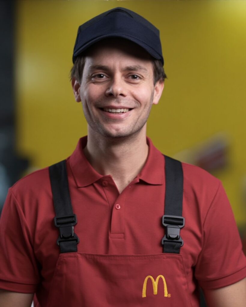 AI-gegenereerde variant van Bo Pennings in McDonald’s-werkkleding, met behoud van gelaatskenmerken, kapsel en uitstraling.