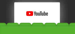 Een groot scherm in een donkere ruimte toont het YouTube-logo, met groene bioscoopstoelen op de voorgrond, wat een bioscoopsfeer creëert.