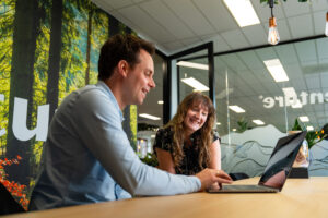 Twee collega’s van Wux bespreken samen een strategie voor een gebruiksvriendelijk navigatiemenu dat bezoekers de weg wijst en conversies verhoogt.