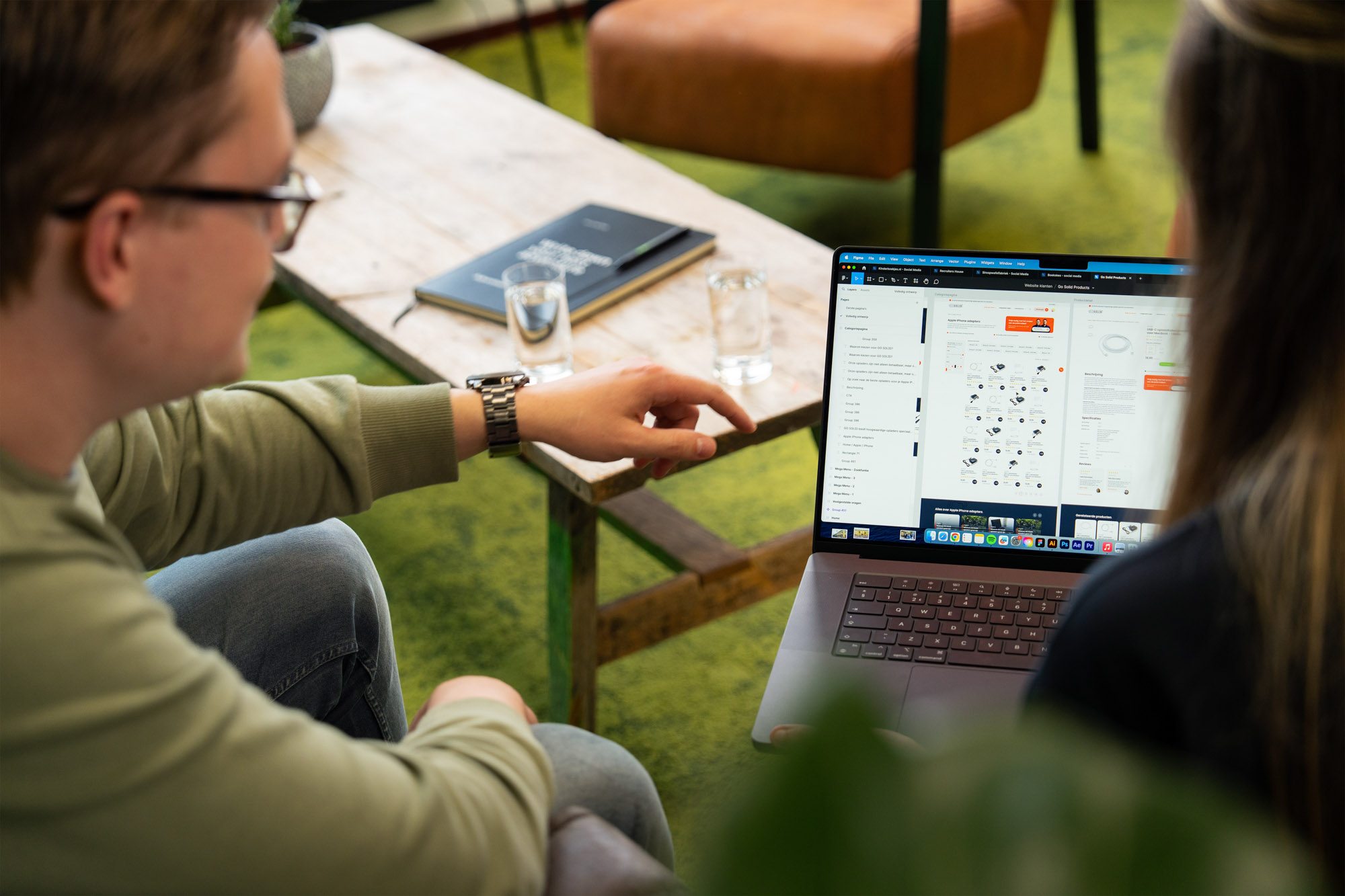 Creatieve werkplek bij Wux waar twee medewerkers samen een functionele WordPress-plugin installeren.