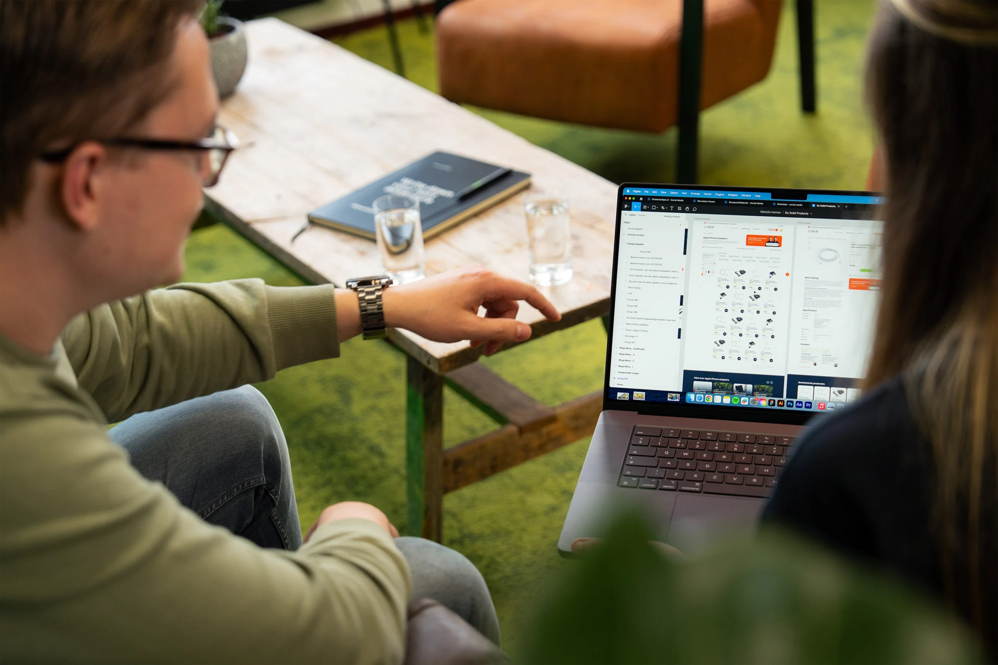 Creatieve werkplek bij Wux waar twee medewerkers samen een functionele WordPress-plugin installeren.