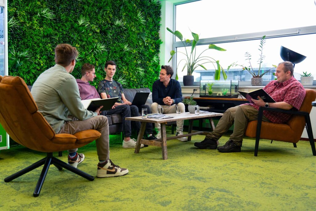 Team bespreekt software management in een informele setting om processen en prioriteiten af te stemmen.