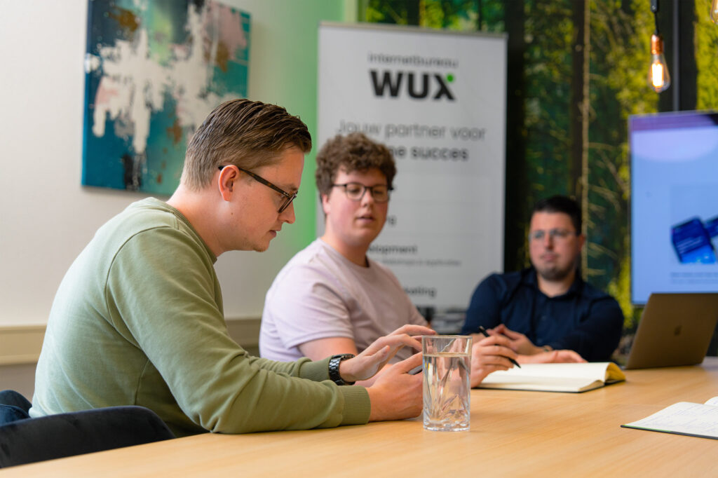 Teammeeting over zoekwoordenonderzoek en contentstrategie op het kantoor van Wux Digital Agency.