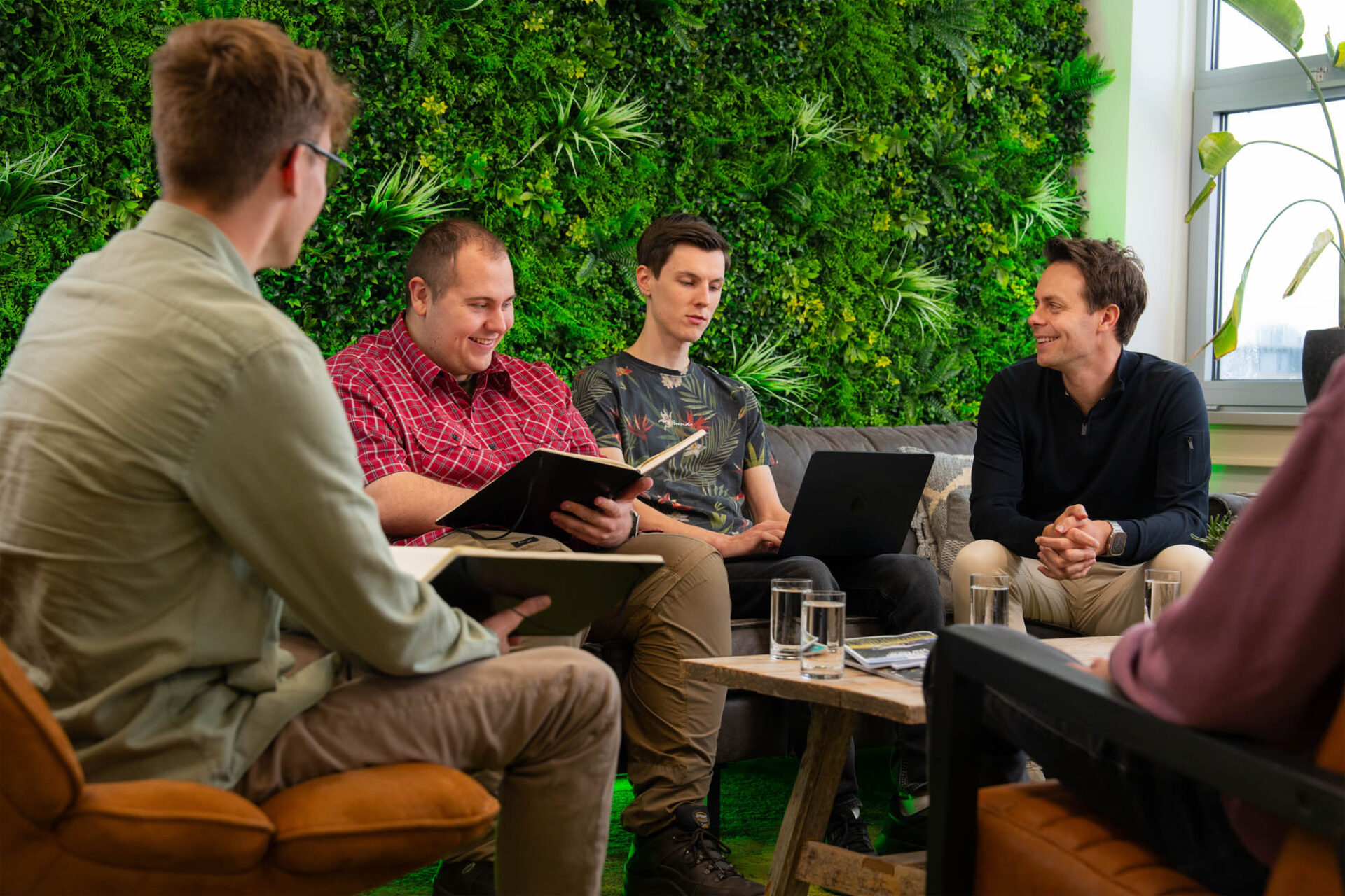Groep collega’s in overleg, die ideeën en expertise uitwisselen voor de inhoud en structuur van een kennisportaal.