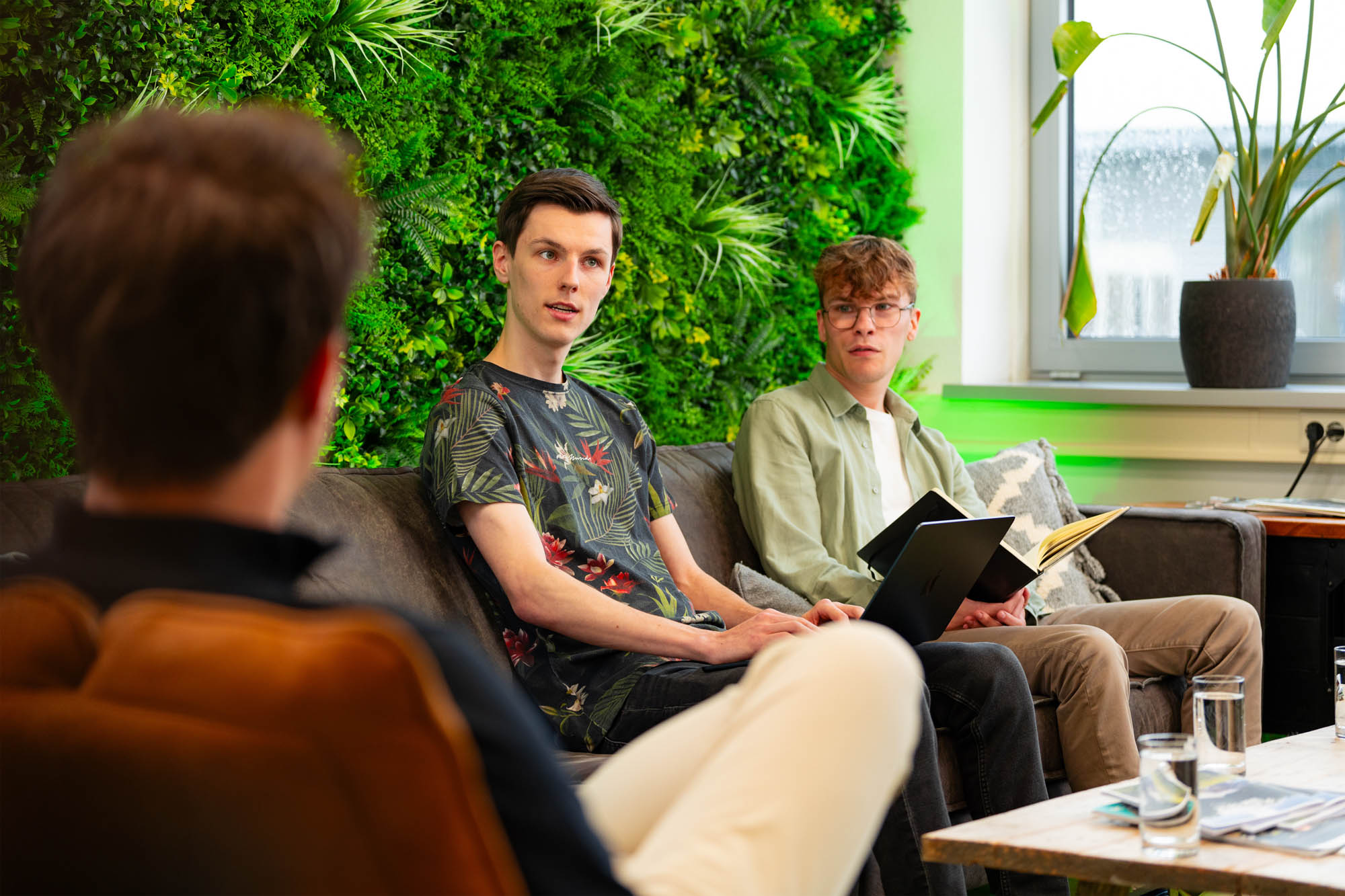 Teamoverleg over strategie en AI-automatisering in de moderne kantooromgeving van Wux.