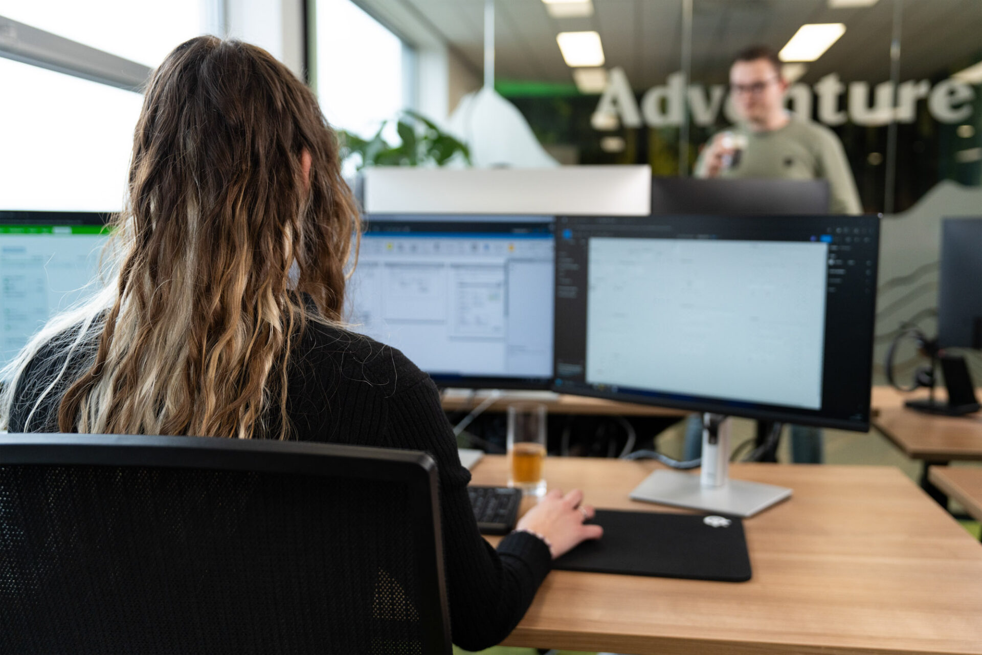 Medewerker achter dubbele monitoren werkt in een digitale omgeving, illustratie voor patiënt- of zorgportaal.