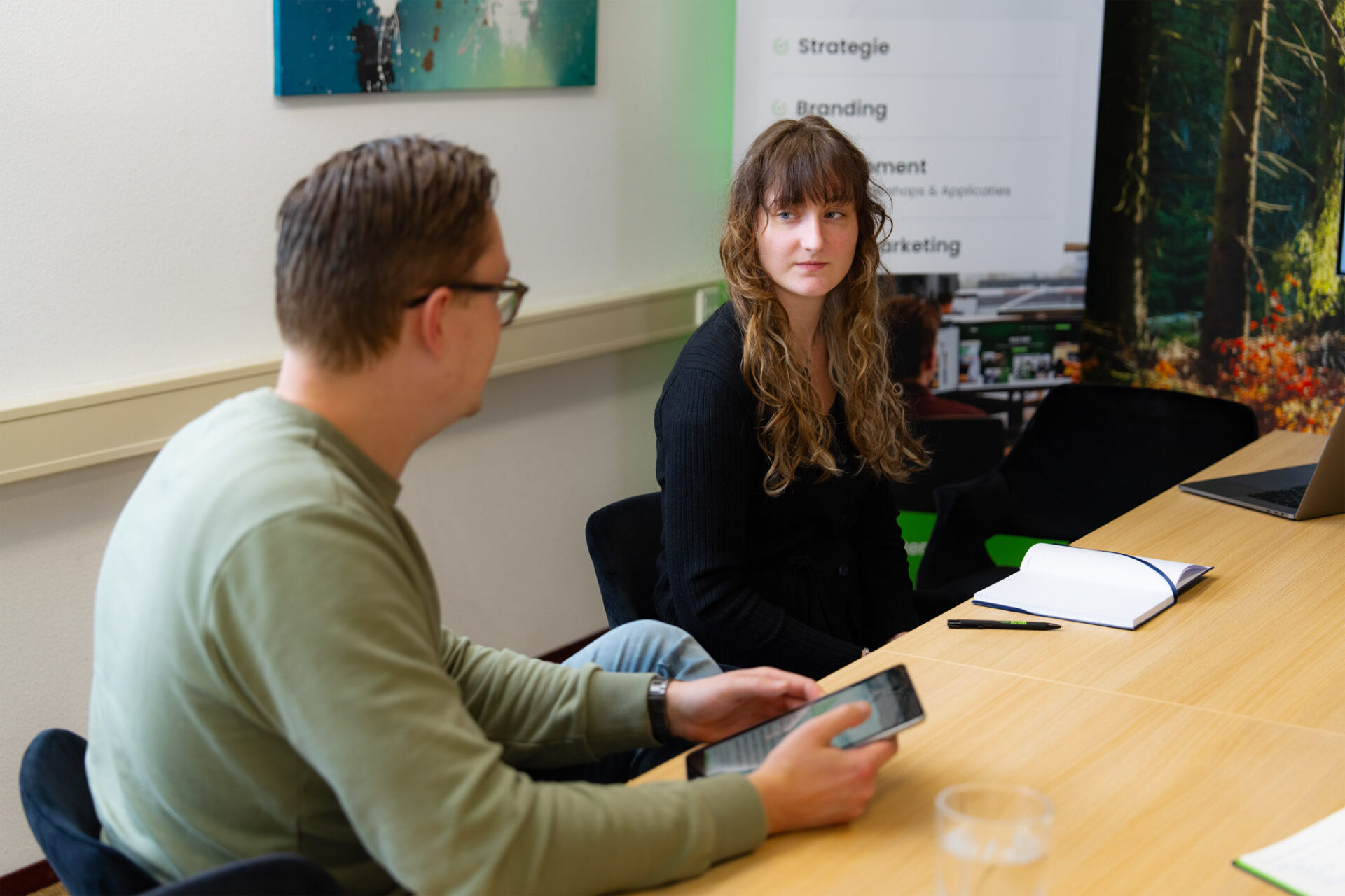 Medewerkers van Wux bespreken de mogelijkheden van een e-commerce portaal tijdens een overleg, met focus op digitale verkoopstrategieën en klantbeleving.