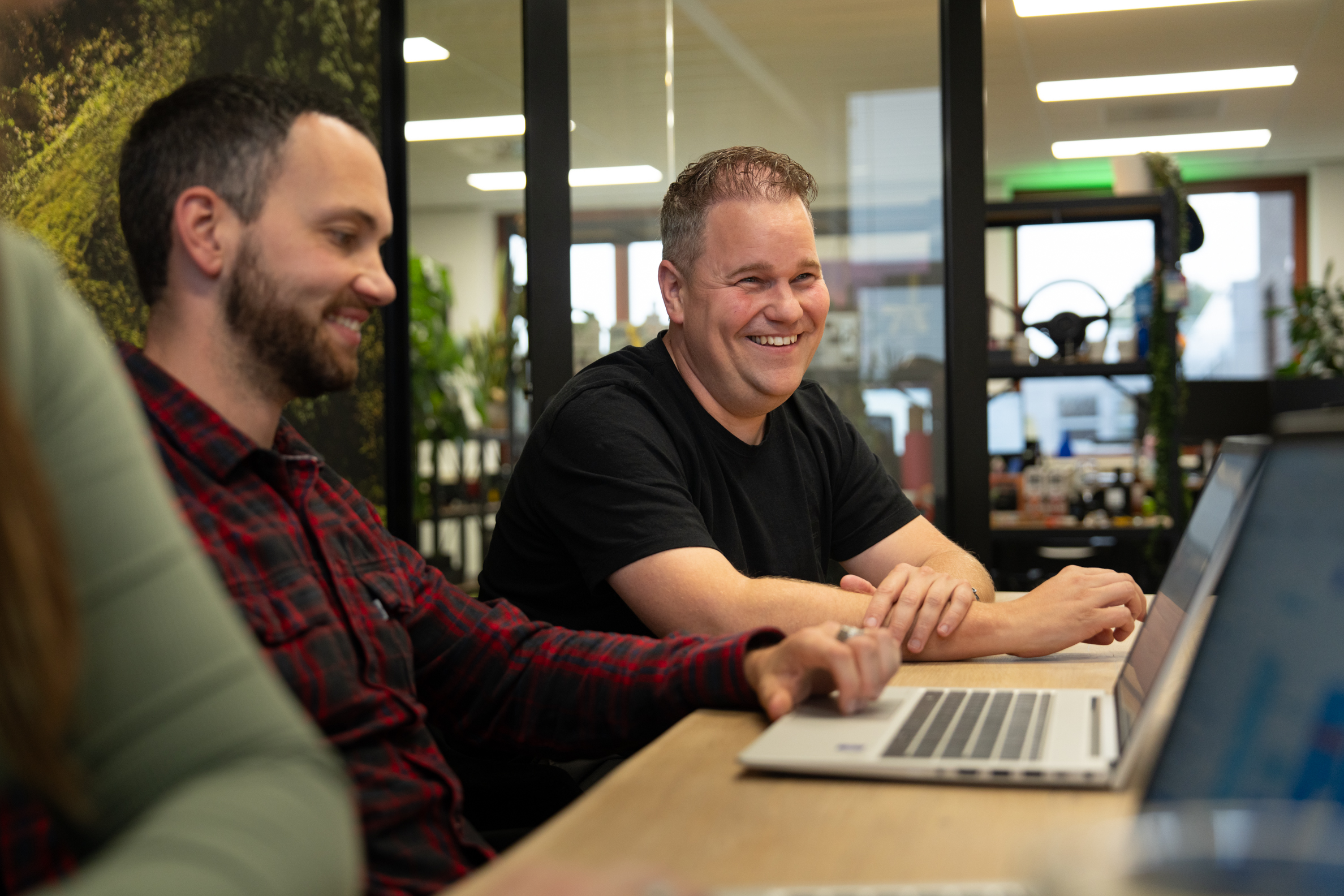 Collega’s van Wux bespreken linkbuilding en domeinautoriteit tijdens een overleg met laptops op tafel.