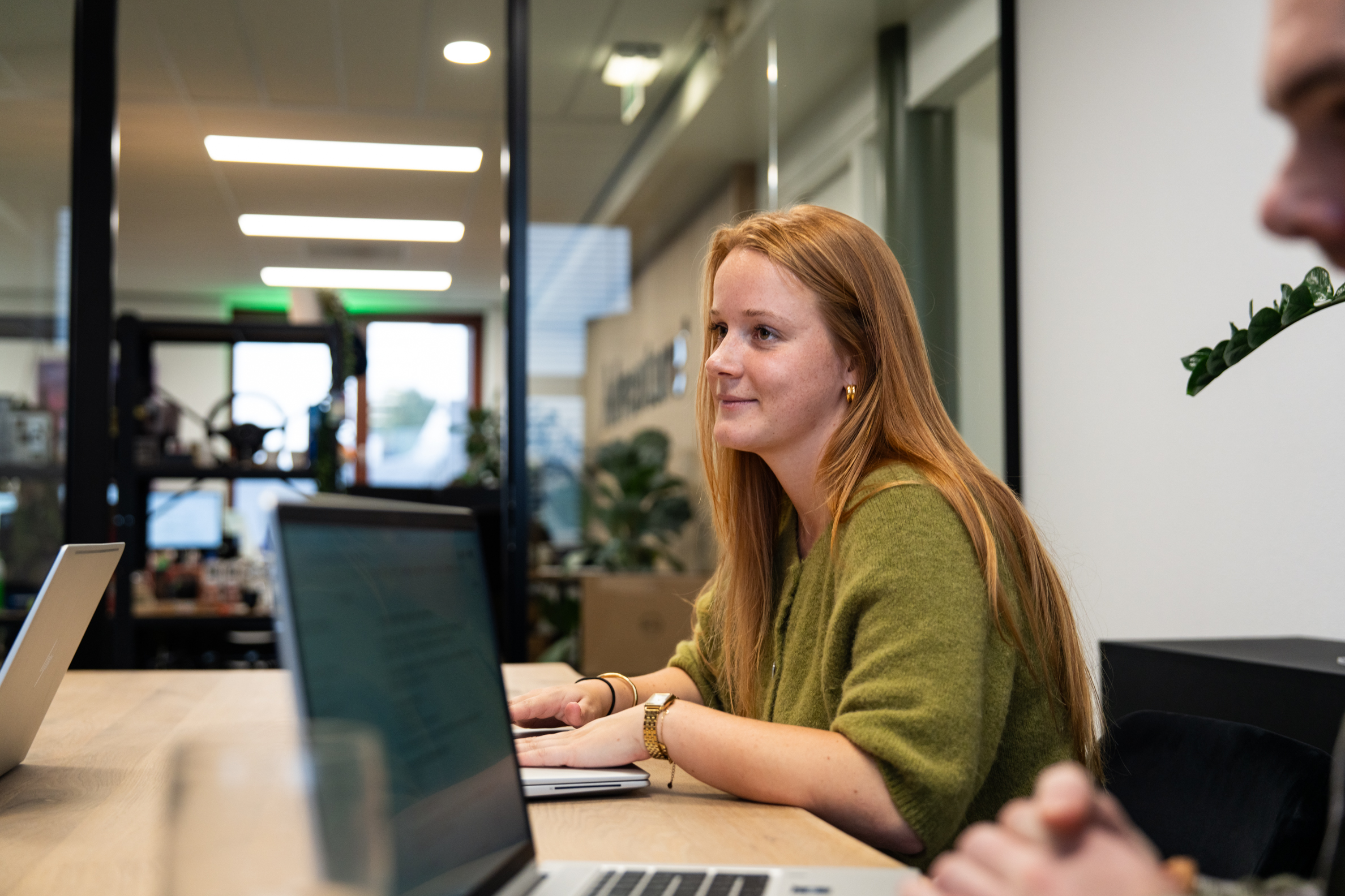 Contentmarketeer werkt aan nieuwe teksten en campagnes op laptop tijdens overleg bij WUX.