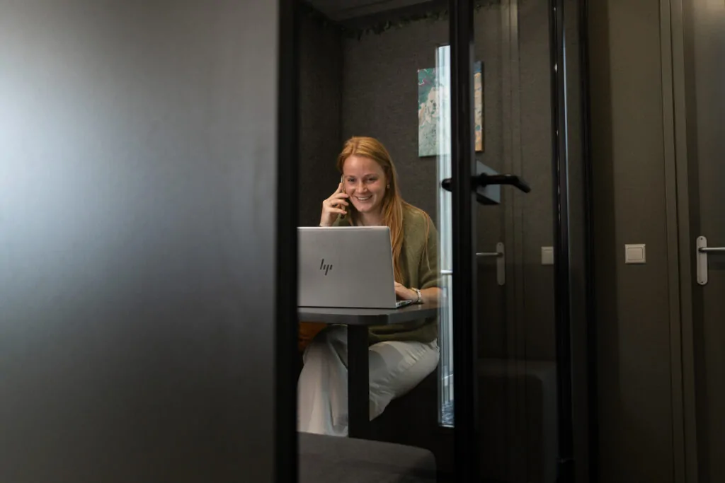 Medewerker van Wux voert telefonisch overleg over linkbuildingcampagnes achter haar laptop.