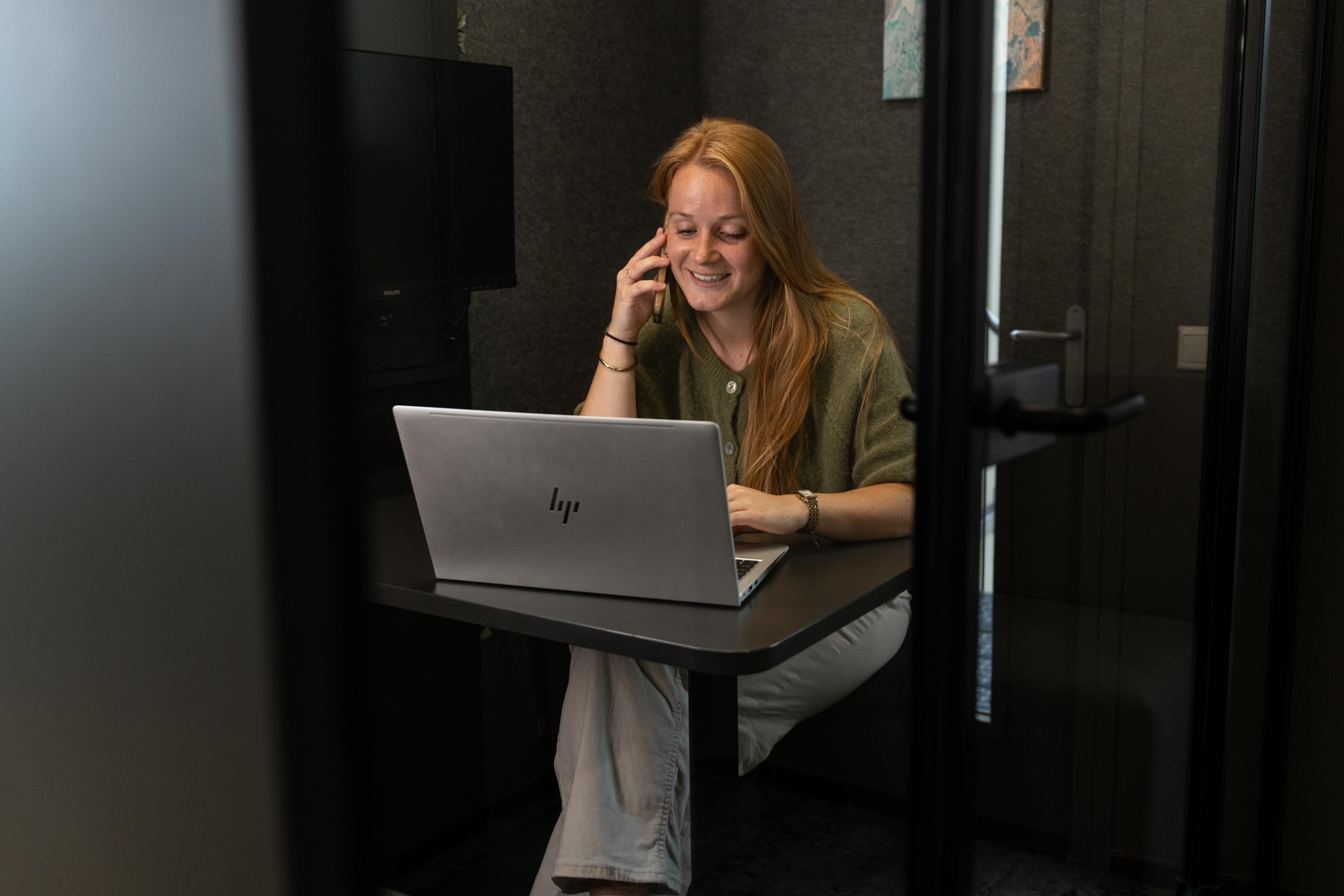 Medewerker van Wux bespreekt telefonisch een SEA-strategie met een klant terwijl ze achter haar laptop werkt.