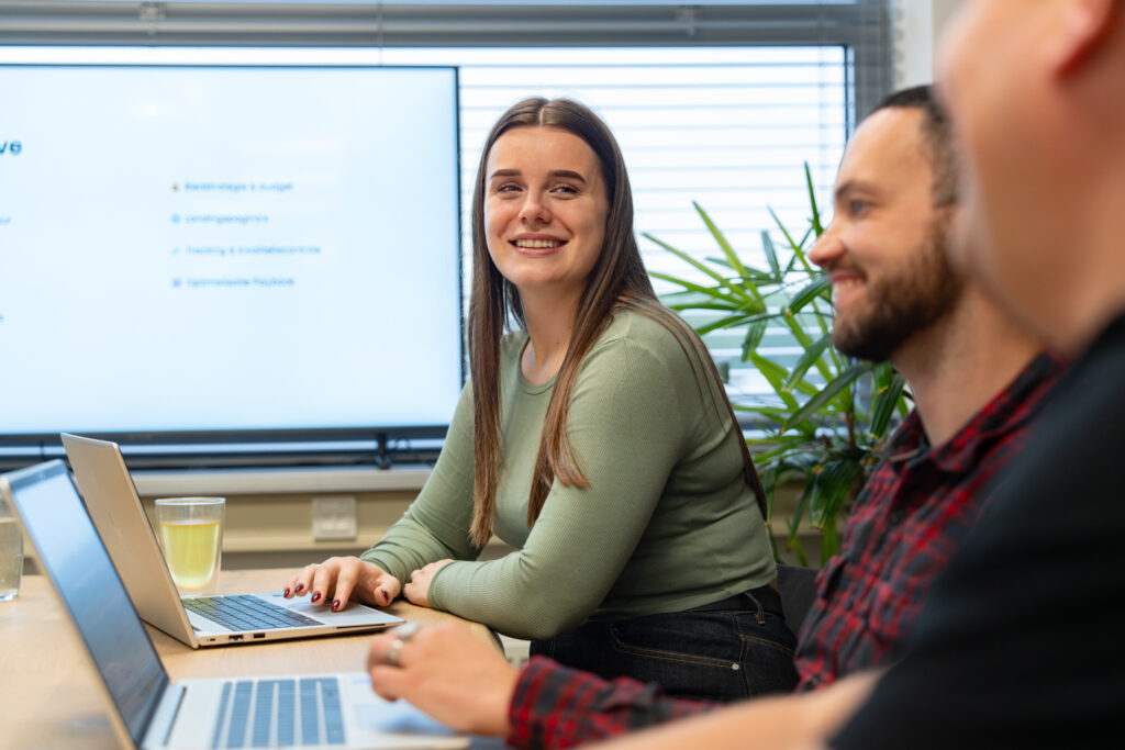 Marketing- en digital team van Wux bespreekt meetbare resultaten van automatisering met KPI-dashboard op achtergrond.