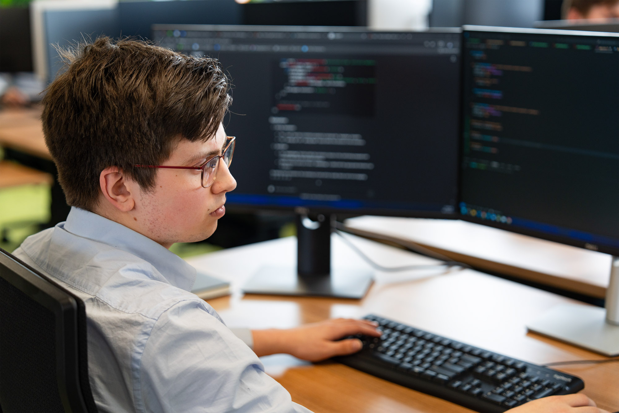 Developer van Wux programmeert een MES systeem om productieprocessen livee te monitoren en te optimaliseren.