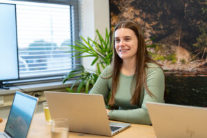 Een medewerker van Wux overlegt met collega’s over AI-ready data in een vergaderruimte met laptops en dashboards.