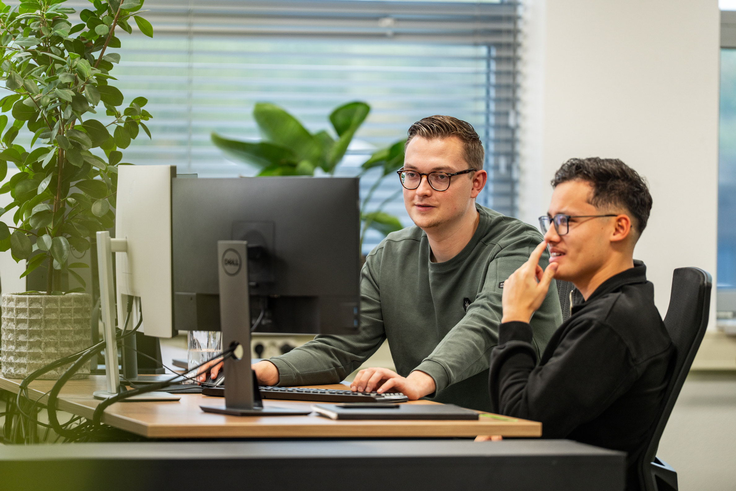 Twee developers van Wux bespreken de functionaliteiten van een Applicant Tracking System tijdens softwareontwikkeling.