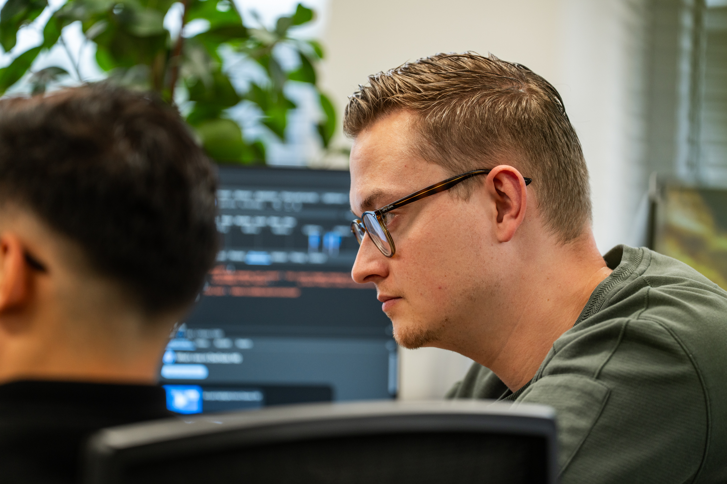 Software engineer van Wux verdiept zich in de ontwikkeling van schaalbare B2B SaaS-oplossingen in een moderne kantooromgeving.