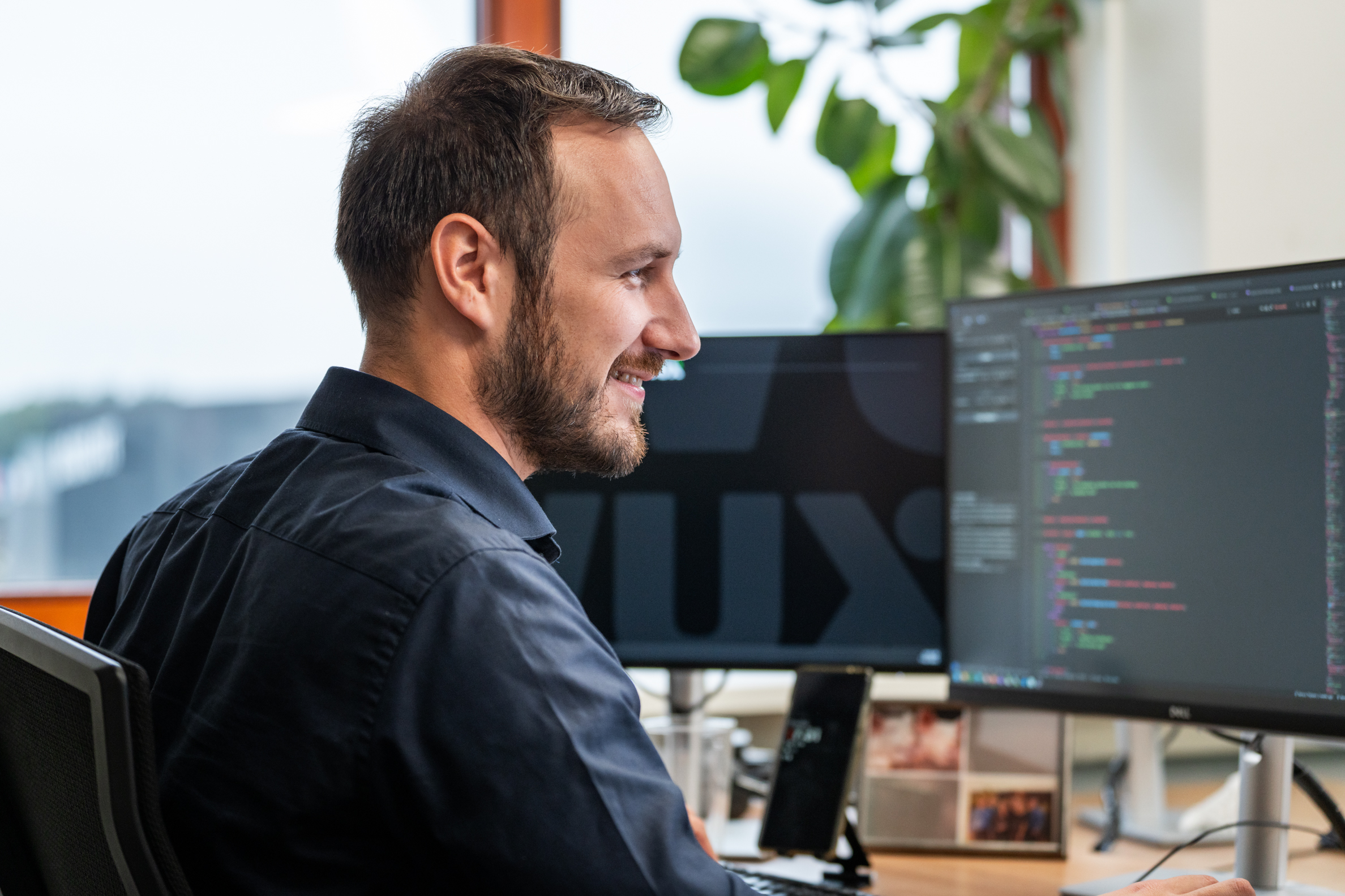Programmeur van Wux analyseert en optimaliseert code voor een PDM softwareoplossing op meerdere schermen.