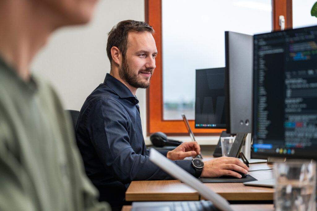 Developer van Wux werkt aan de ontwikkeling van een Document Management Systeem op kantoor.