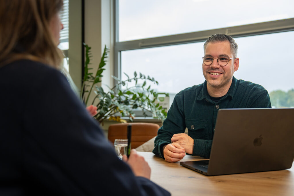 Mederwerker van Wux overlegt met klant over de ondersteuning en doorontwikkeling van een nieuw CRM systeem