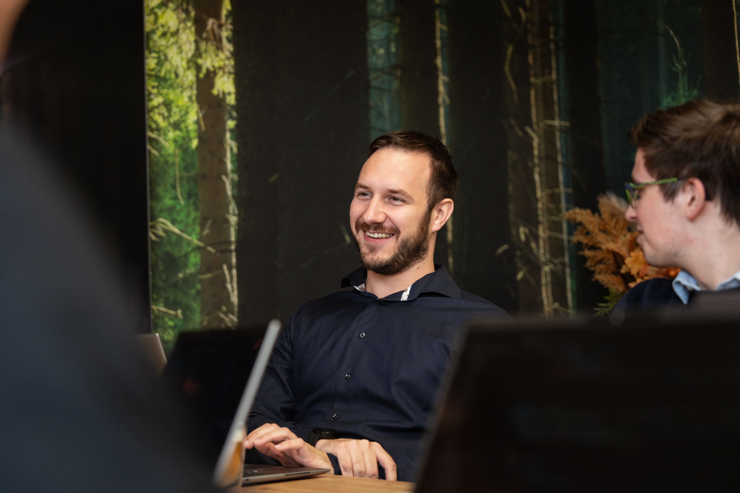 Teamlid van Wux lacht tijdens overleg over het optimaliseren van software systemen voor bedrijven.