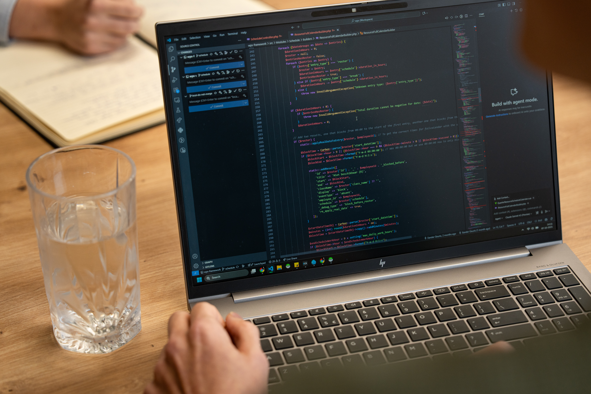 Developer van Wux schrijft code voor de ontwikkeling van bedrijfssoftware systemen tijdens een overleg.