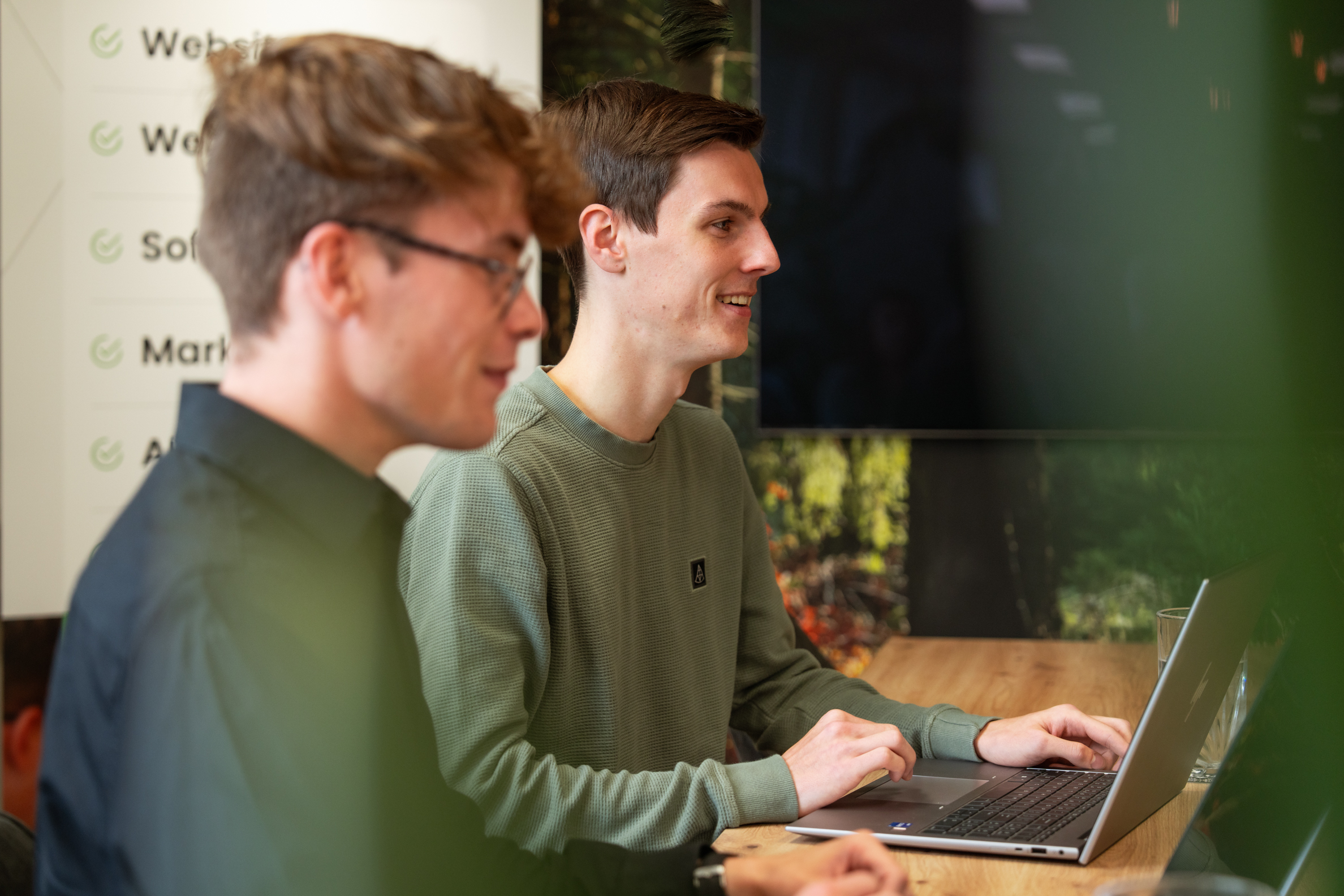 Twee developers van Wux bespreken de architectuur en werking van software systemen op kantoor.