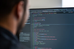 Developer van Wux werkt aan de technische kant van een website, met focus op hosting en onderhoud in de code-editor.