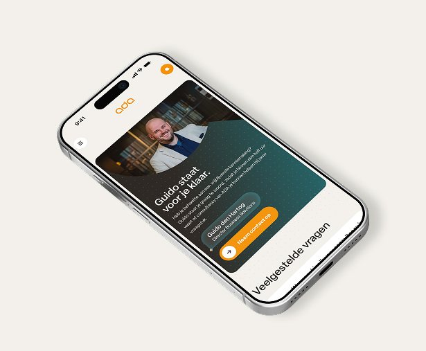 Een witte smartphone die een mobiele pagina van de ADA ICT-website toont. In beeld is een uitnodigende contactsectie met een lachende foto van Guido den Hartog, Director Business Solutions. Daarbij staat de tekst "Guido staat voor je klaar" en een oranje knop om direct een vrijblijvende kennismaking voor consultancy aan te vragen.