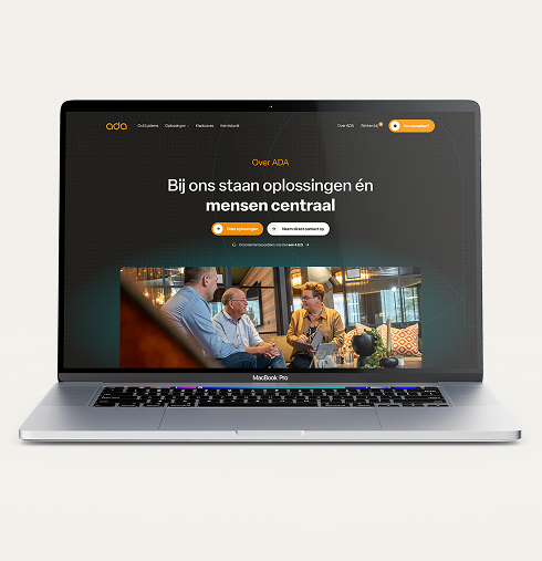 Een laptop die de 'Over ADA' pagina toont op de desktopversie van de ADA ICT-website. Centraal op het scherm staat de tekst "Bij ons staan oplossingen én mensen centraal", met daaronder de foto van drie collega's tijdens een ontspannen overleg op de bank.