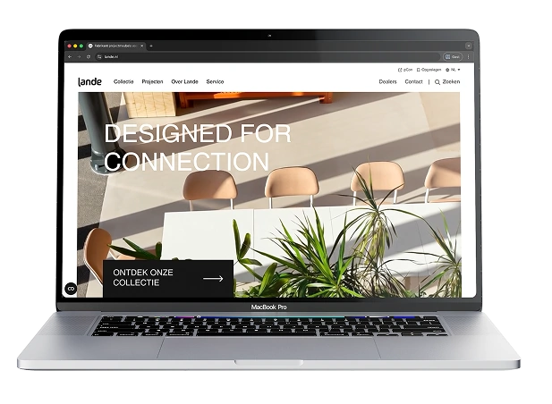 Een zilveren MacBook Pro waarop de homepage van de Lande website open staat. Het scherm toont een zonnige, sfeervolle foto van een witte tafel met stoelen en groene planten, met daaroverheen de grote witte tekst "DESIGNED FOR CONNECTION". Linksonder staat een zwarte knop met de tekst "ONTDEK ONZE COLLECTIE".