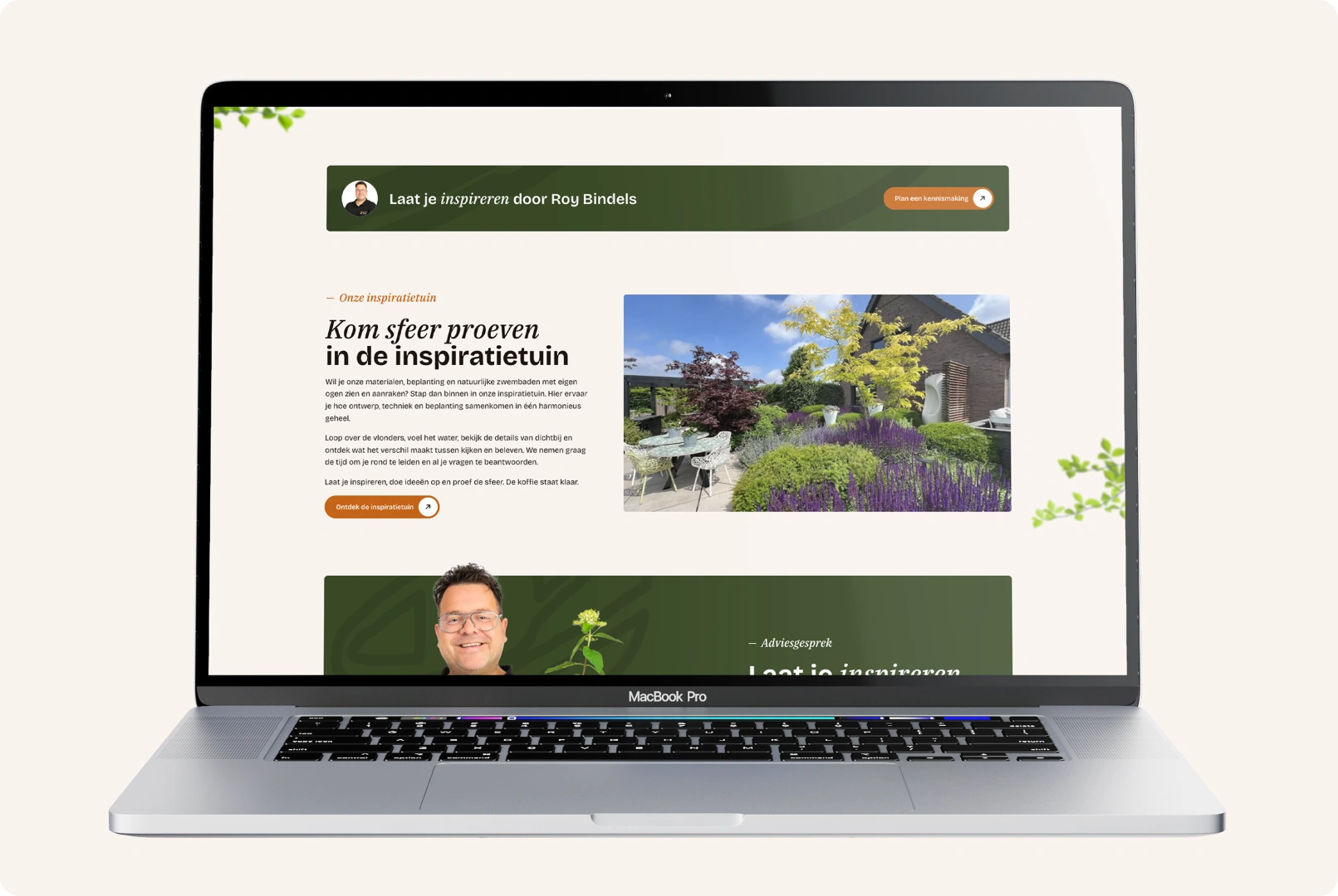Een geopende MacBook Pro die een sectie van de Bindels Buiten Beleving website over de inspiratietuin toont. Op het scherm staat de uitnodigende titel "Kom sfeer proeven in de inspiratietuin" naast een grote, kleurrijke foto van een prachtig aangelegde showtuin met een terras, zitmeubilair en weelderige beplanting. Boven de sectie is een smalle groene banner te zien met de tekst "Laat je inspireren door Roy Bindels", en onderaan begint een sectie voor het aanvragen van een adviesgesprek.
