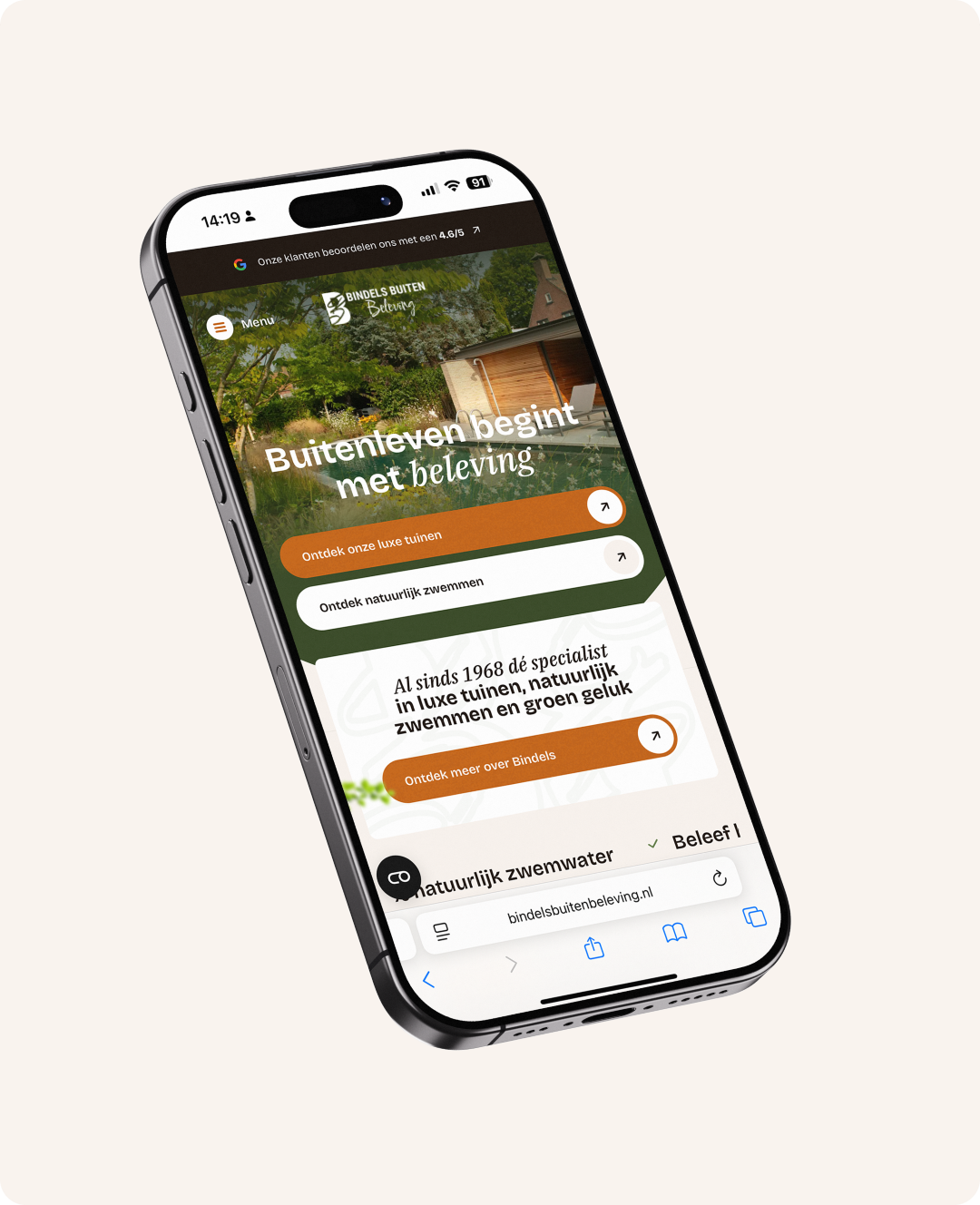 Een schuin afgebeelde smartphone die de mobiele weergave van de website van Bindels Buiten Beleving toont. Het scherm toont de homepagina met de slogan "Buitenleven begint met beleving" en grote knoppen voor het ontdekken van luxe tuinen en natuurlijk zwemmen.