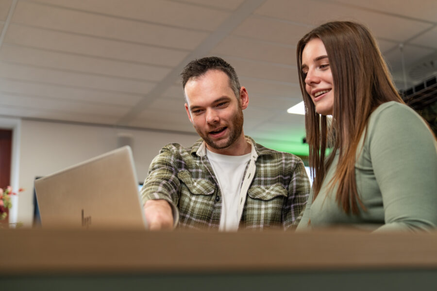 Twee Wux-medewerkers werken samen achter meerdere beeldschermen aan de implementatie van het CRM-opschoonproces.