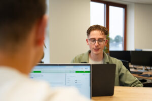 Een UX-designer van Wux bespreekt de resultaten van een conversie-onderzoek met een collega.