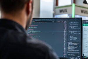 Een ontwikkelaar van Wux analyseert de code en error logs op het scherm om een serverstoring op te lossen.