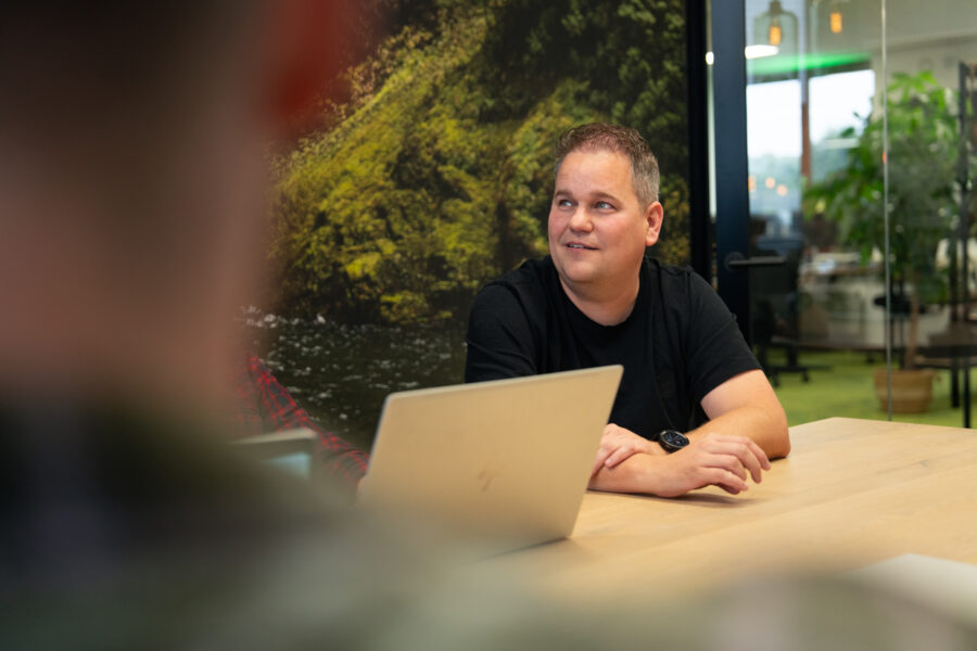 Een specialist van Wux bespreekt de budgetverdeling voor de social advertentiestrategie tijdens een overleg.