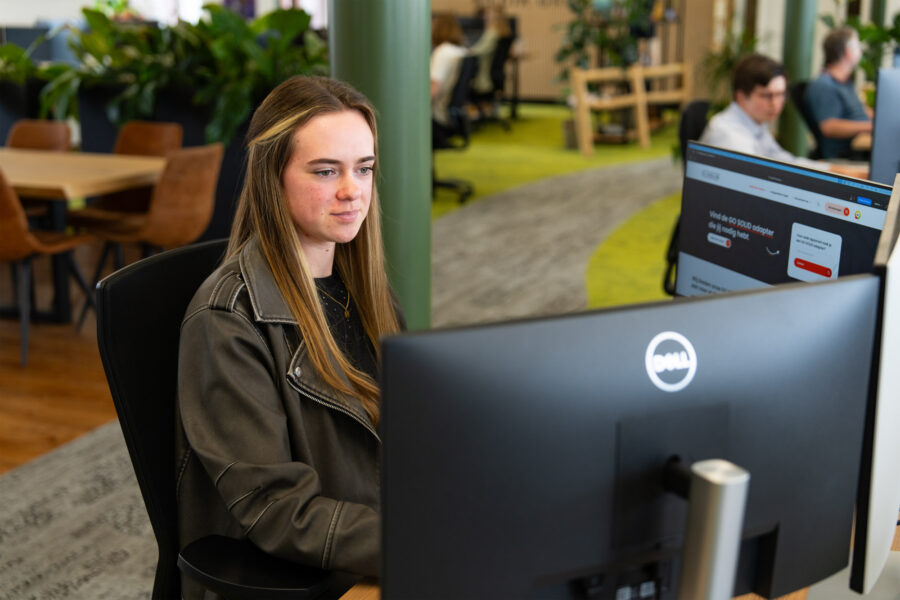 Een medewerker van Wux werkt aan het sneller maken van een webshop op een groot scherm.